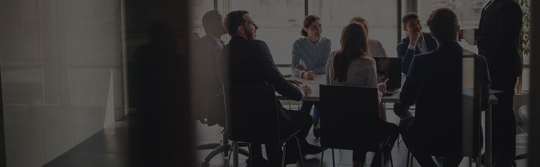 group of people meeting a conference room in an office