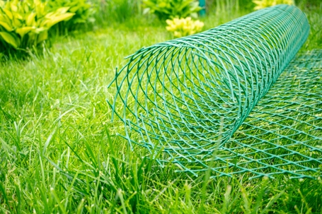 roll of plastic mesh is lying on the lawn