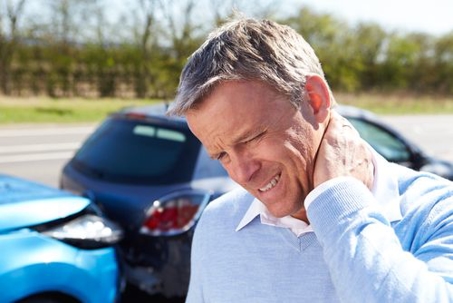 man holding his neck after car crash