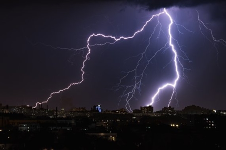 image of lightning striking over a city